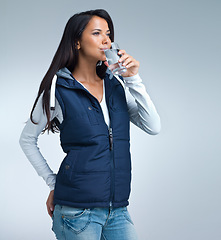 Image showing Woman, drink water for health and hydration in studio, nutrition and wellness with thirst on grey background. Liquid, aqua and mineral with h2o in glass, fresh and clean for refreshment and detox