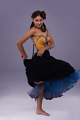 Image showing Dancer, studio or woman in dress dancing with energy, freedom or fashion in portrait for style. Spanish, purple background or artist in flamenco, tango or performance in musical culture or tradition