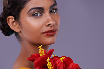 Image showing Portrait, beauty and woman with flowers for skincare, makeup or mockup isolated on a purple studio background in India. Face, model and cosmetics with bouquet for natural skin with organic hibiscus