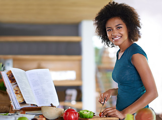 Image showing Cooking, portrait and happy woman cutting vegetables with recipe book in kitchen for healthy diet, nutrition or lunch. Chopping board, food or face of African person preparing organic meal in home