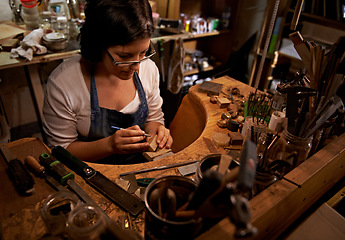 Image showing Woodworking, tools and artist in workshop with creative project or sculpture on table at night. Artisan, carpenter and woman with talent for creativity in dark studio in process of carving wood