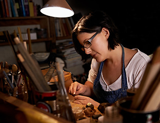Image showing Woodworking, tools and artist in workshop with creative project or sculpture on table at night. Artisan, carpenter and woman with talent for creativity in dark studio in process of carving wood