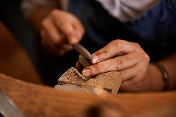 Image showing Carving, wood and hands of artist with tools in workshop for creative project or process of sculpture on table. Artisan, carpenter and person closeup with talent in studio for unique woodworking