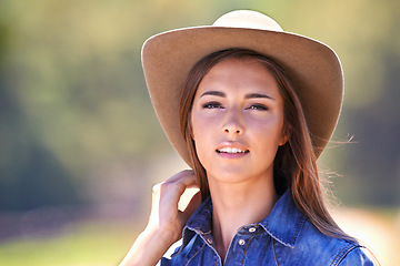 Image showing Cowgirl, portrait and hat at farm, nature and western fashion for agriculture, work and outdoor in summer. Woman, person or farmer at ranch for sustainability, countryside and environment in Texas