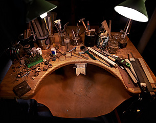 Image showing Woodworking, tools and table in workshop for artist in sculpture to start project at night. Dark, studio and creative workspace for carpenter with equipment on desk for process and production