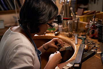 Image showing Carving, wood and artist in workshop with creative project or unique sculpture on table at night. Artisan, carpenter and woman with talent for creativity in dark studio in process of woodworking