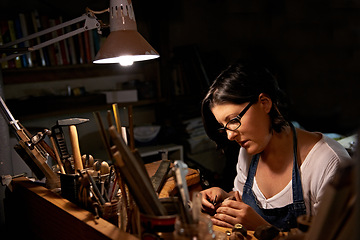 Image showing Wood, carving and artist in workshop with creative project or unique sculpture on table at night. Artisan, carpenter and woman with talent for creativity in dark studio in process of woodworking