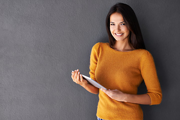 Image showing Portrait, tablet and smile with woman in studio for streaming, social media and technology. Happiness, online shopping and webiste with face of femal person on wall background for interent blog