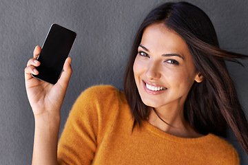 Image showing Woman, portrait and phone screen in studio, blank and mockup space for website or app. Female person, breeze and empty display for marketing or advertising, social media and online by gray background