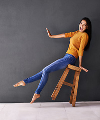 Image showing Woman, stool and fashion for style, trendy and portrait for smile and apparel in clothes and excited. Female person, silly and lean on chair for wardrobe, confident and elegant funny and mockup