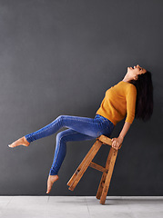 Image showing Woman, chair and fashion for style, trendy and laugh for smile and apparel in clothes and excited. Female person, excited and lean on stool for wardrobe, confident and elegant beauty and mockup