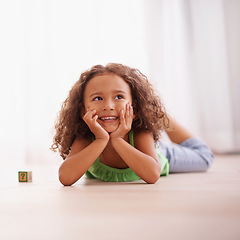 Image showing Girl, smile and learning alphabet with blocks in home, child development and growth with letters. Female person, kid and abc on floor of living room, happy and creative game for education with toys