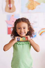 Image showing Girl, smile and learn with blocks in portrait, child development and growth with letters. Female person, kid and abc or alphabet for language, kindergarten and creative game for education at school