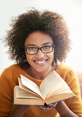 Image showing Book, portrait and black woman in living room to read for literature, leisure and hobby at home. Smile, education and face of female student in lounge for learning, knowledge and information