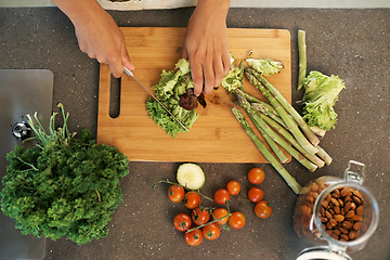 Image showing Hands, knife and above for vegetables in kitchen with chopping, asparagus and cooking with nutrition for dinner. Chef, person and meal prep with vegan diet for food, wellness and lunch in apartment