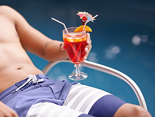 Image showing Man, relax and drink at swimming pool with cocktail at hotel, resort and travel on luxury vacation. Summer, holiday and glass of alcohol in hand on deck at poolside in Miami with hospitality closeup