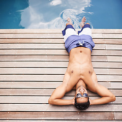 Image showing Pool, deck and man relax in summer with happiness at hotel, resort or above villa in Miami for vacation. Calm, holiday and person lying in sunshine at poolside with freedom and peace in Florida