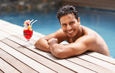 Image showing Man, relax and portrait at swimming pool with cocktail at hotel, resort and travel on luxury vacation. Summer, holiday and glass of alcohol to drink with happiness on deck at poolside in Miami