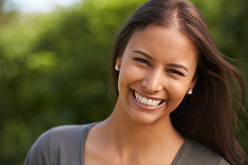 Image showing Portrait, happy and woman in a park for travel, adventure or calm morning walk in nature. Face, smile and female person relax outdoor with sunshine, fresh air and confidence, break and feel good mood