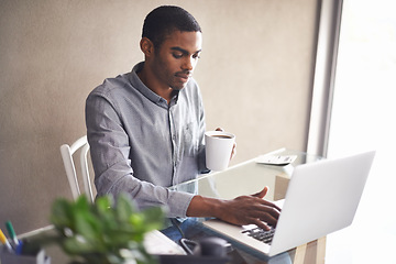 Image showing Laptop, drinking coffee and black man in home office for business, remote work or typing email. Tea, computer and serious freelancer at desk for accounting, bookkeeping or calculation on internet