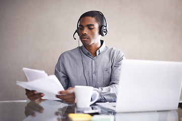 Image showing Businessman, laptop and headphones with paperwork for call center, online advice or consulting at office. Black man, consultant or African employee with documents and computer for customer service