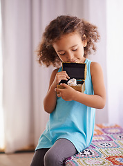 Image showing Child, gift and toy in home, happy and surprise toys for girl and school reward for childhood development. Daughter, relax or smile for present in bedroom, play or curious for treasure box in house