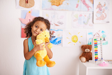 Image showing Girl, portrait and cute with duck to cuddle in bedroom for comfort or playtime, smile and innocent. Child, adorable and hug stuffed animal for youth and happiness with bonding embrace for development