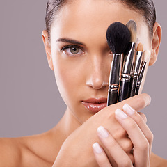 Image showing Woman, beauty and brush with makeup, portrait and studio for glamour and radiance and lip gloss. Female person, blush cosmetics and foundation in grey background, tools and attractive confidence