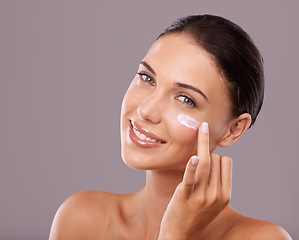 Image showing Portrait, cream and woman with skincare, beauty and dermatology on grey studio background. Face, person and model with lotion and shine with wellness and cosmetics with moisturise, glow and aesthetic