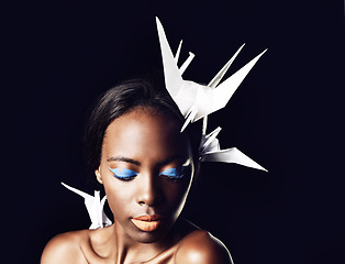 Image showing Black woman, makeup and fine art with cosmetics, origami birds or dove on a dark studio background. Closeup or face of African female person or model with beauty or blue eye shadow on mockup space