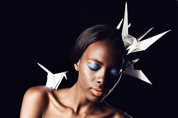 Image showing Black woman, makeup and fine art with beauty, cosmetics or origami birds on a dark studio background. Closeup or face of African female person or model with dove or blue eye shadow on mockup space