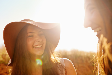 Image showing Women, friends and nature with summer hat for travel, holiday and vacation together in lens flare. Happy and young people in countryside for fashion, talking and laughing with outdoor and cool style