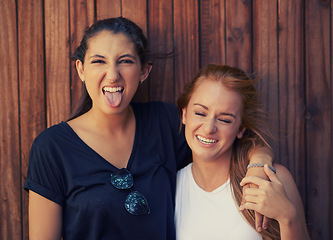 Image showing Portrait, tongue out and woman friends on wooden background together for bonding or relationship. Love, funny face or laughing and happy young people having fun with fashion in summer for holiday