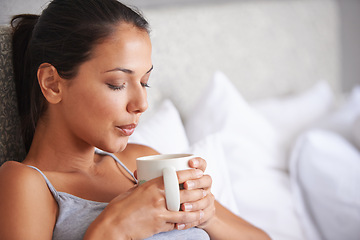 Image showing Woman, coffee and bed for relax in morning for wakeup and drink in cup for warm and steam with pillow. Young person with beverage for blow caffeine on weekend for boost in mug with pajamas