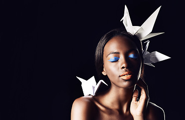 Image showing Black woman, makeup and fine art with beauty, origami birds or cosmetics on a dark studio background. Closeup or face of African female person or model with dove or blue eye shadow on mockup space