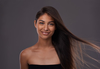 Image showing Hair care, wind and portrait of happy woman for skincare or beauty isolated on a gray studio background. Hairstyle, cosmetics and face of Indian model in salon with makeup at hairdresser for glow