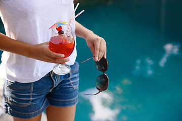 Image showing Person, hands and cocktail at pool in summer on holiday or vacation with luxury hospitality at hotel. Alcohol, drink and guest relax outdoor at villa with fashion, style and sunglasses by water