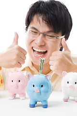 Image showing Asian businessman saving money