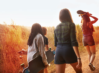 Image showing Summer, nature and friends walking with skateboard on path in countryside or exercise on holiday or vacation. Women, hiking and relax outdoor together on trail, trekking on hill or travel environment