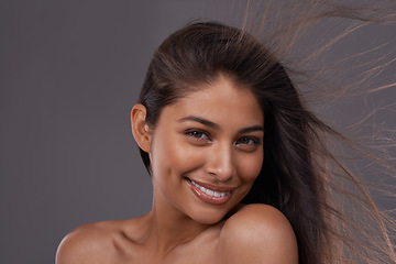 Image showing Hair, wind and portrait of happy woman in makeup for beauty or shine isolated on a gray studio background. Hairstyle, skincare and face of Indian model in salon with cosmetics at hairdresser for care