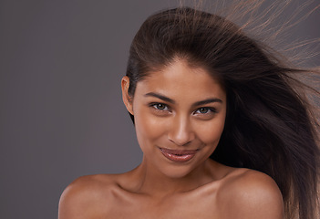 Image showing Hair, wind and portrait of happy woman for skincare, beauty or shine isolated on a gray studio background. Hairstyle, cosmetics and face of Indian model in salon with makeup at hairdresser for care