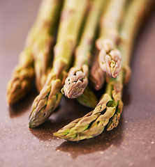 Image showing Vegetable, healthy and asparagus for cooking, food and nutrition at home, house and kitchen with macro on table. Sparrow grass, edible plants and fresh produce for vegan dish, clean eating and diet