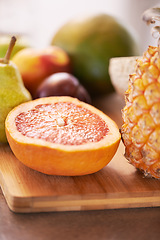 Image showing Kitchen counter and fruit recipe on cutting board for healthy, meal and nutrition for wellbeing, diet and self care. Home, fresh and organic food for lunch with orange and pineapple to prepare juice