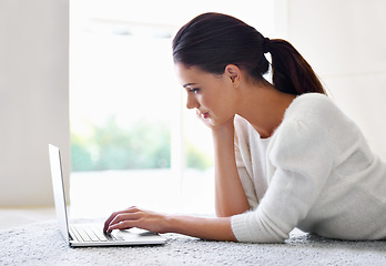 Image showing Laptop, floor and woman in house for remote work, social media or reading email on internet. Computer, freelancer and person on carpet with technology for networking, typing and relax in apartment