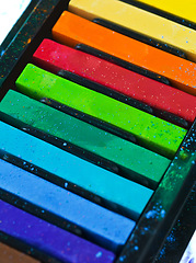 Image showing Paint, pastel and color chalk in studio for rainbow or vibrant creativity, texture and pigments for fine or visual arts. Oil or watercolor sticks, set or palette to shade or blend with composition.