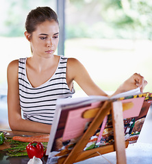 Image showing Cooking, book and kitchen with woman, vegetables and vegetarian with recipe and ingredients. Home, girl and person with skills and nutrition with diet plan and lunch with healthy meal and wellness