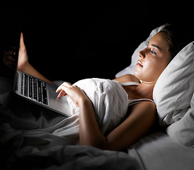 Image showing Bed, laptop and night with woman streaming content, video or browsing social media in dark home. Bedroom, computer and subscription with young person in apartment to relax on weekend time off