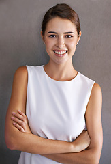 Image showing Portrait, happy woman or arms crossed in studio for ambition and confident person by brown background. French lady, designer and smile on face for career growth and positive attitude in creative job