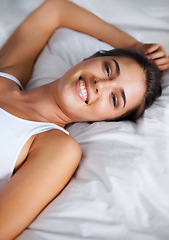 Image showing Portrait, relax and smile from woman on bed of apartment, comfortable and rest on soft mattress. House, morning and female person wake up from dream on pillow with happiness for break on weekend