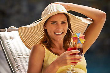 Image showing Woman, cocktail and drink by swimming pool on lounge chair for summer, holiday and tropical vacation. Young person or tourist in portrait by hotel with hat, glass or alcohol for happy, outdoor break